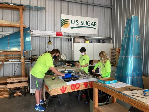 Students Paul Moyers, Max Friedland and Zalan Guilbert assemble an airplane kit as part of the Teen Aircraft Factory of Manasota program.